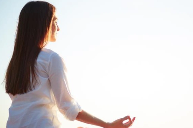 Woman Meditating at Sunrise
