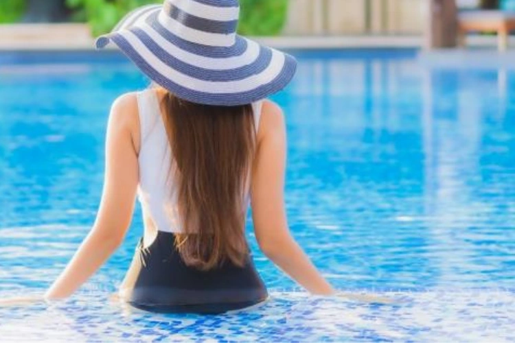 Woman Relaxing in Pool with Sun Hat
