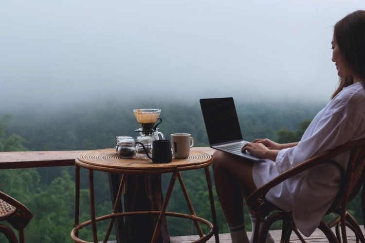 Woman working on a laptop on a balcony